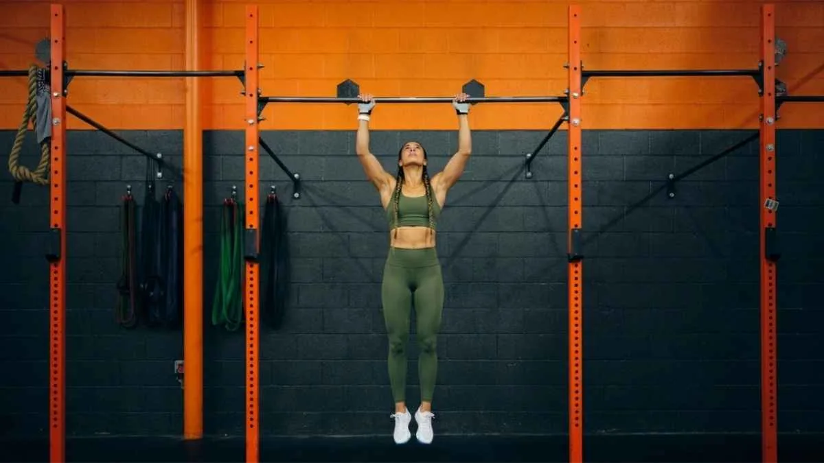 Mulher realizando exercício na barra fixa