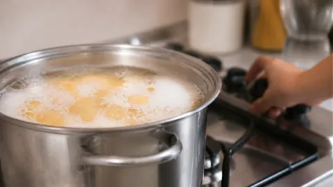 Panela com macarrão fervendo e espuma próxima da borda
