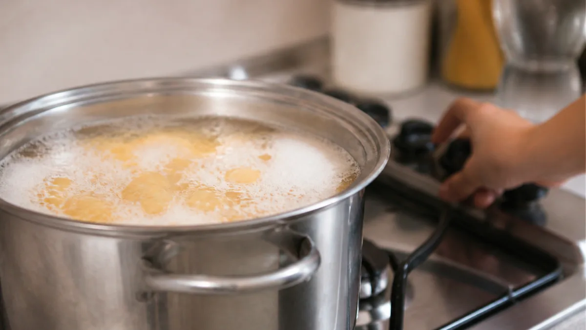 Panela com macarrão fervendo e espuma próxima da borda