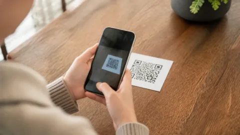 Pessoa tentando escanear um QR Code com o celular
