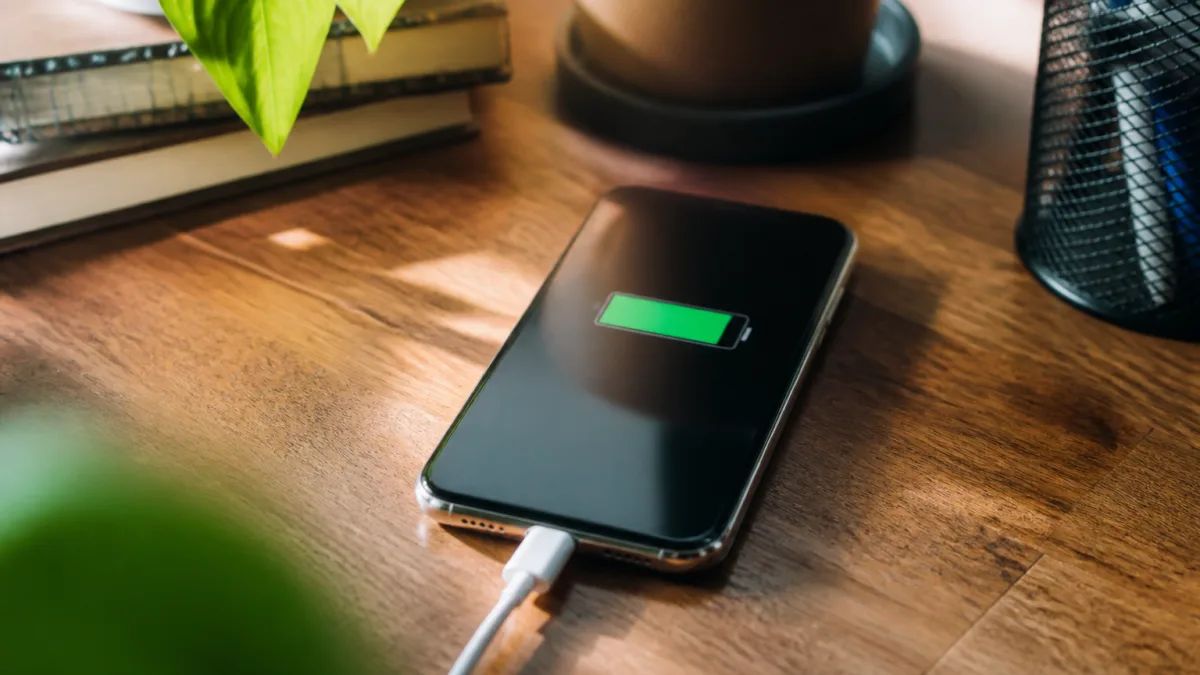 Celular conectado ao carregador sobre uma mesa