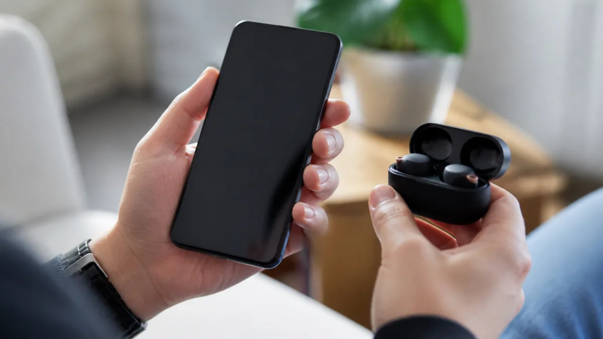 Pessoa conferindo a conexão de um fone Bluetooth no celular