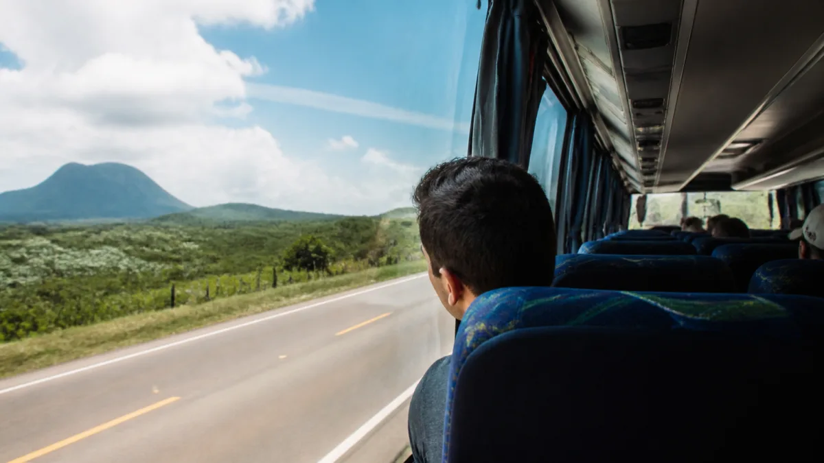 Passageiro sentado na parte dianteira de um ônibus durante uma viagem