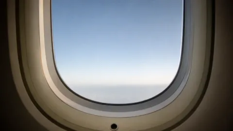 Pequeno furo na janela de um avião visto da cabine