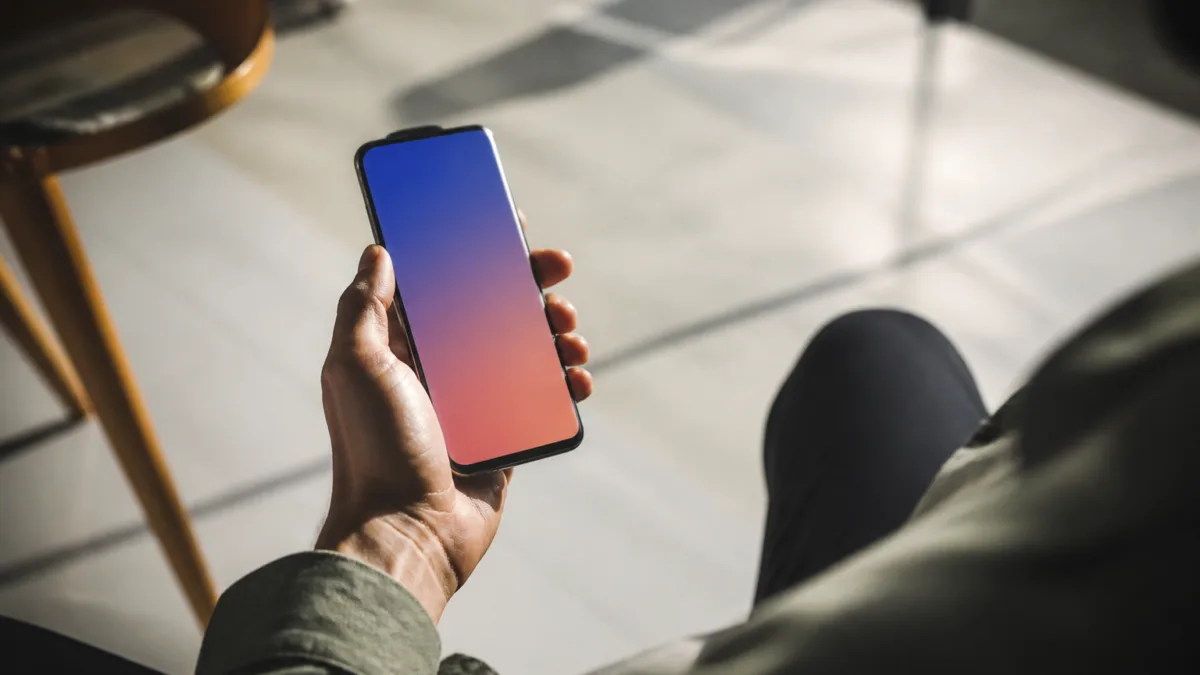 Pessoa usando celular em ambiente com variação de luz