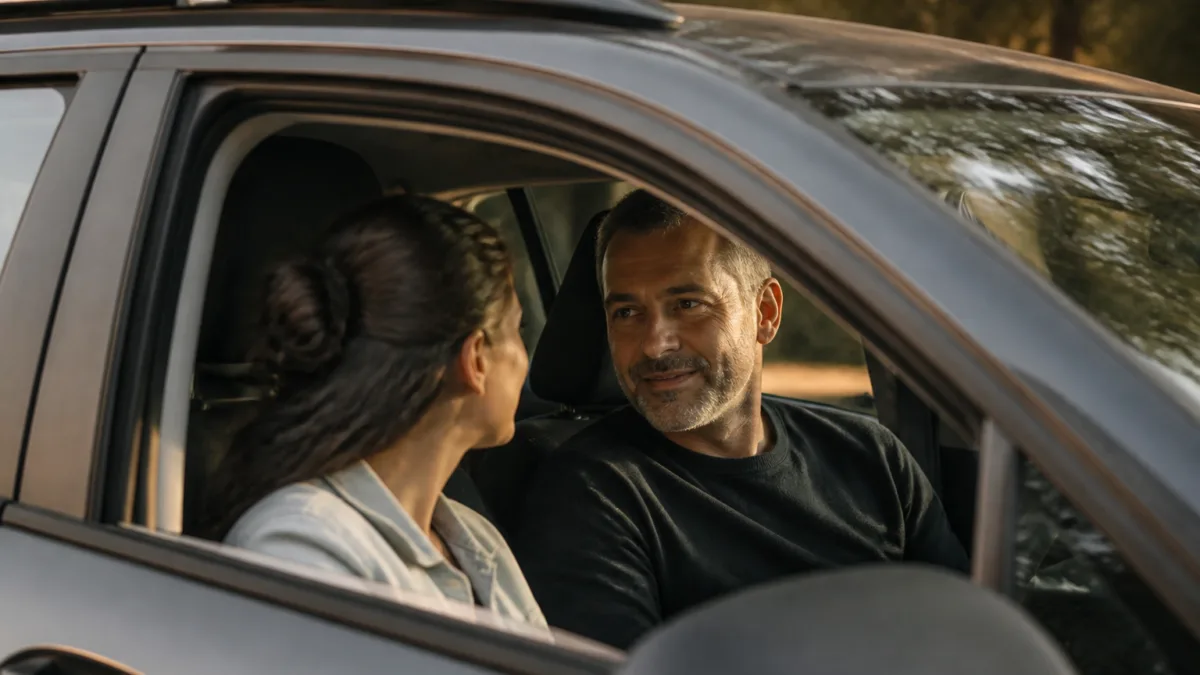 Duas pessoas conversando dentro de um carro ao fim da tarde