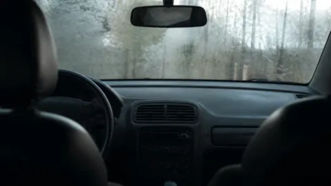 Para-brisa de carro embaçado por dentro em manhã fria