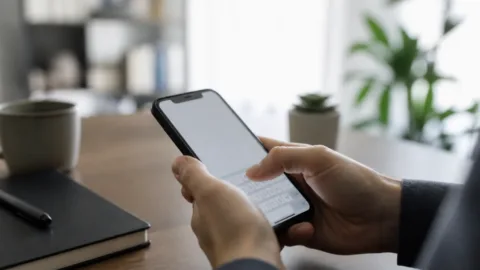 Pessoa digitando em um celular com teclado virtual