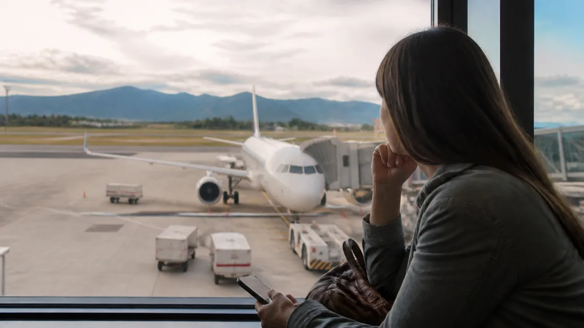 Passageiro observa o aeroporto pela janela do avião